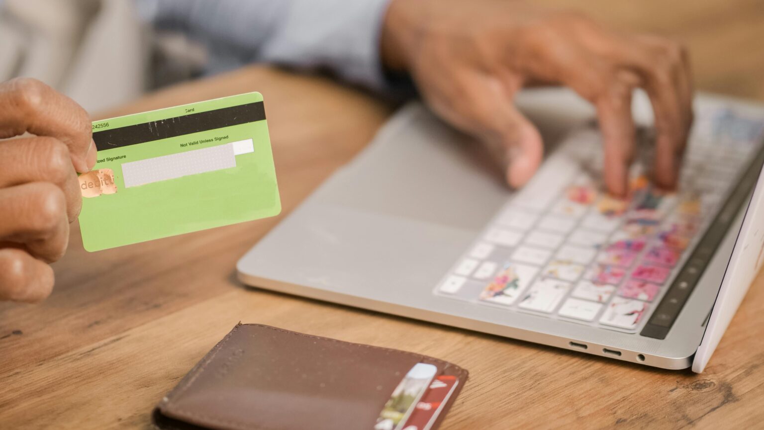 someone at a computer holding a credit card