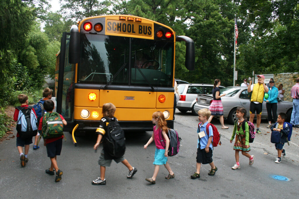 kids in a line boarding a yellow school bus on the first day of school