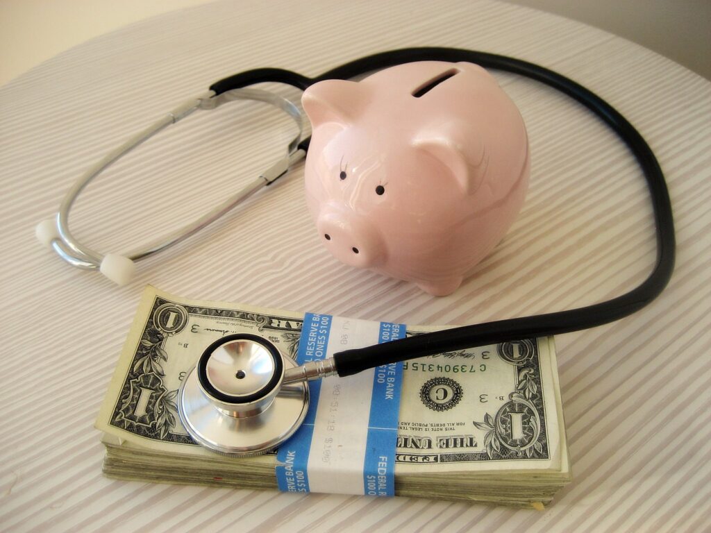 a piggy bank with a stethoscope on a table with some cash 