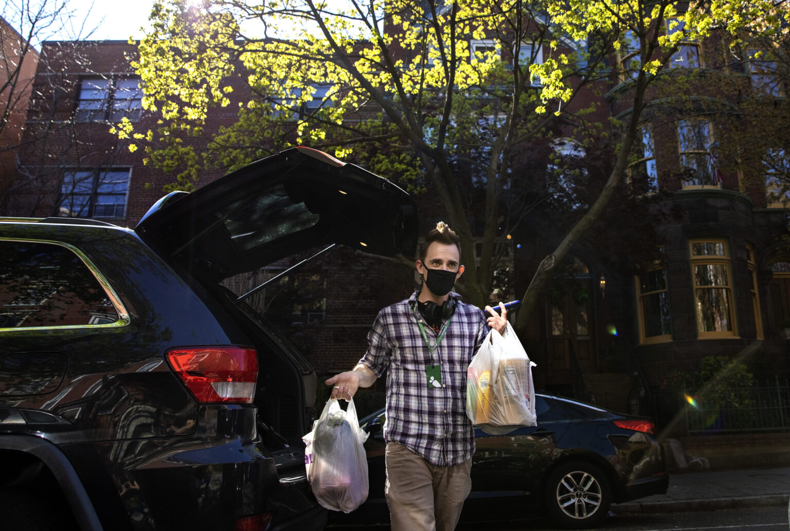 WASHINGTON,DC-APR6: Matt Gillette, a 36 year-old Instacart shopper, makes a grocery delivery in Washington, DC, April 6, 2020. For the past two years he's been part of the gig economy, driving for Lyft, doing handiwork on TaskRabbit. The work was so unstable he's been on the verge of homelessness, crashing with some friends and asking others to take in his beloved dog, a lab mix named Nitro. For years there has been talk of a divided America, of an economy that's highly beneficial to some and detrimental to others. The wrath of a highly contagious, sometimes lethal virus has shown us where, precisely, it stands: at the front door. On one side are people who have the luxury of staying safely at home, working -- or not -- and ordering whatever they want to be delivered. On the other side are those doing the delivering. (Photo by Evelyn Hockstein/For The Washington Post via Getty Images)