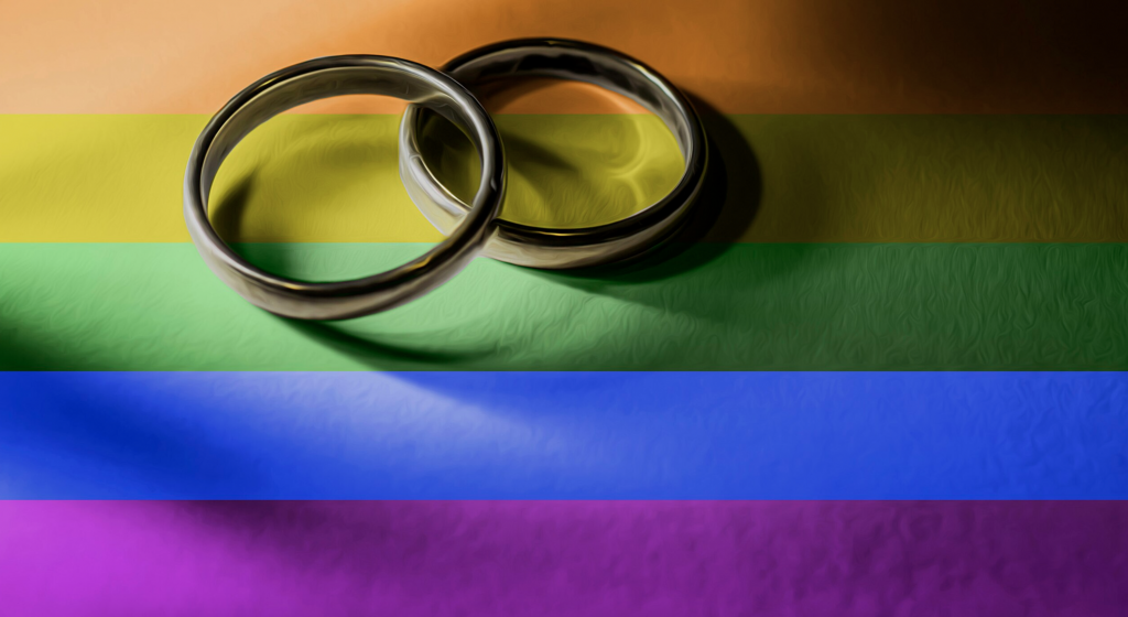 two wedding bands against a rainbow background