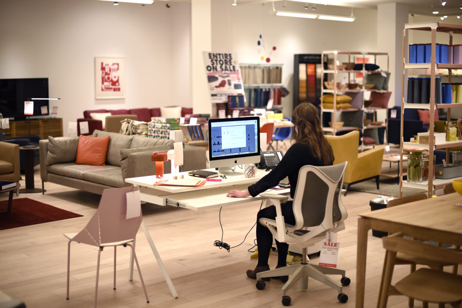 SANTA FE, NEW MEXICO - JANUARY 14, 2020: An employee works at her computer in a home and office furniture and accessory store in Santa Fe, New Mexico.