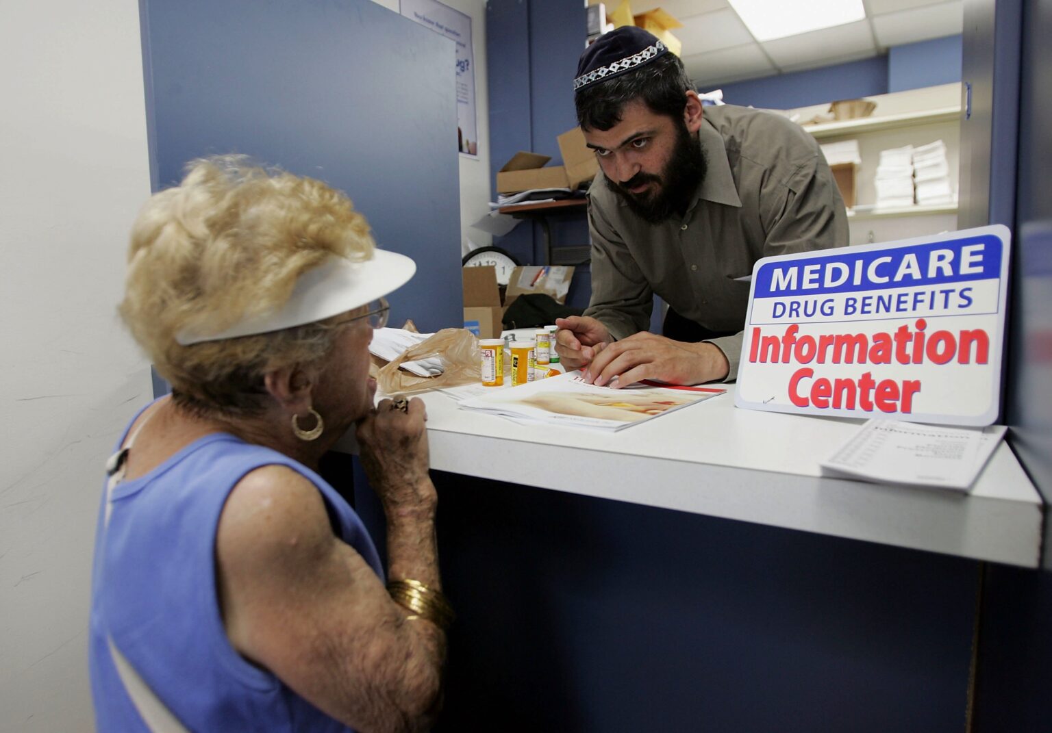 DEERFIELD BEACH, FL - MAY 15: Mayer Kotlarsky, owner of The Village Pharmacy store, speaks with Kay Stein who has questions about the Medicare Drug Plan she signed up for May 15, 2006 in Deerfield Beach, Florida. Today is the deadline for the 5 million eligible Americans who still haven't chosen a plan.