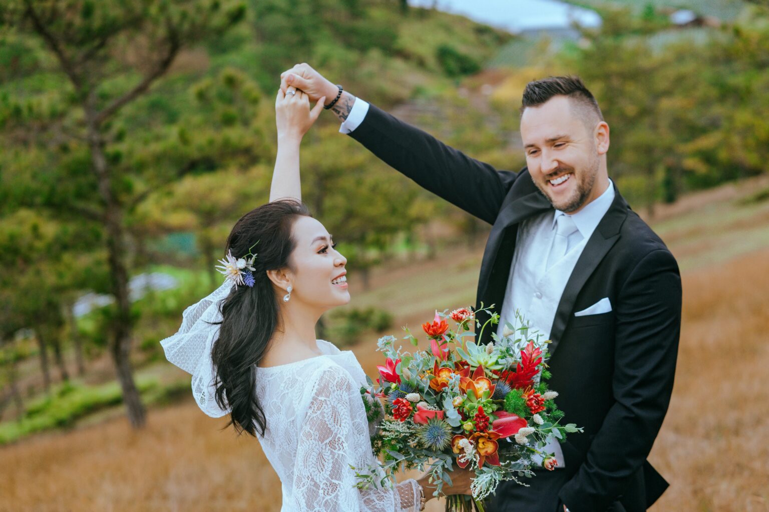 a groom spins his bride in an outdoor setting